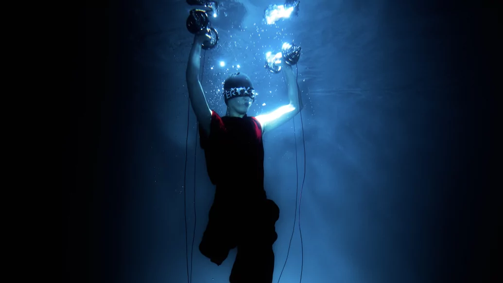 Photo of Tzusing underwater holding dumbbells above his head