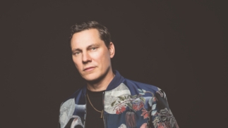 Tiesto poses in front of a black background