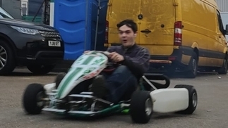 Photo of DJ Drinkwater riding on a go-kart