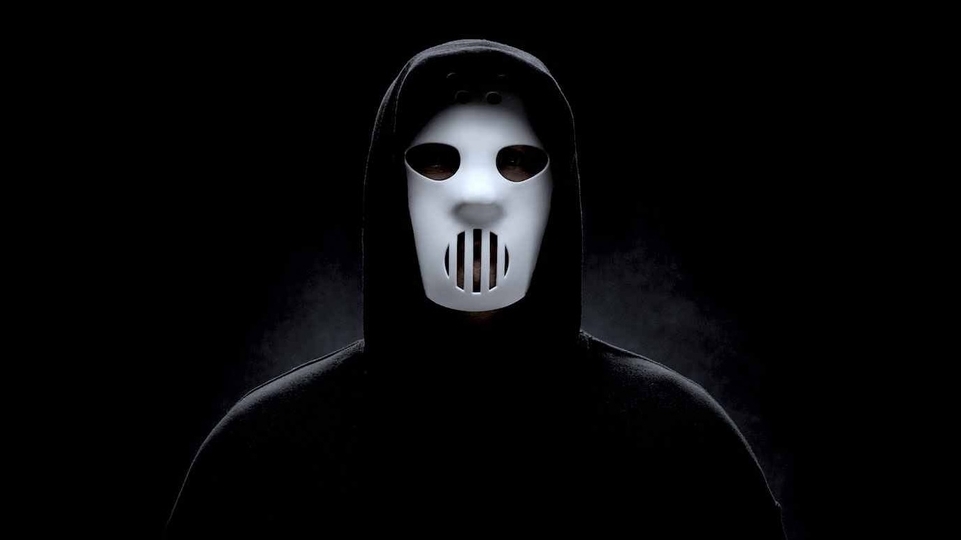 Photo of Angerfist wearing a white mask and black cloak